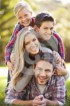 Portrait Of Family Lying On Grass In Countryside