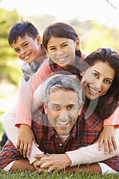 Portrait Of Family Lying On Grass In Countryside