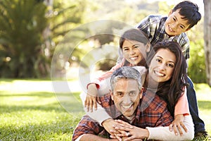 Portrait Of Family Lying On Grass In Countryside