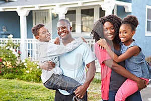 Portrait Of Family Outside Suburban Home