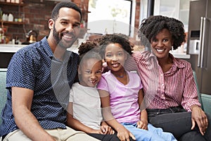 Portrait Of Family Relaxing On Sofa At Home Together