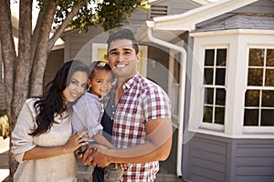 Portrait Of Family Standing Outside Home