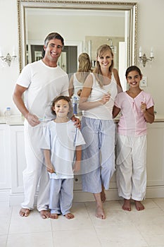 Portrait Of Family About To Brush Teeth In Bathroom Mirror