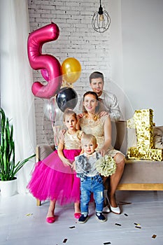 Portrait of a family with two children. Birthday party. The family celebrates the birthday of their daughter and son