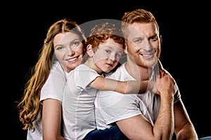 Portrait of family in white t-shirts hugging each other