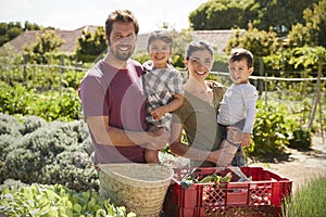 Portrait Of Family Working On Community Allotment Together