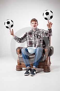 The portrait of fan with balls, holding dish on gray background