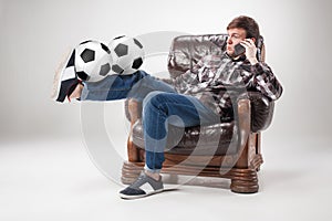 The portrait of fan with balls, holding phone on gray background