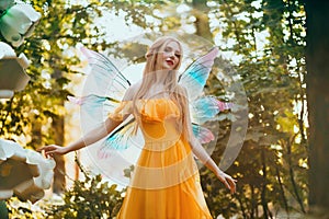 Portrait fantasy woman blonde forest fairy. Elf girl fashion model in bright yellow dress, butterfly wings. Pixie walks