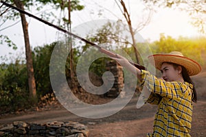 Portrait the farmer asea woman wearing a hat at the shooting range shot from a muzzle-loading vintage gun in the farm, Young girl