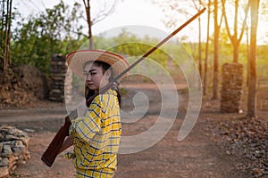 Portrait the farmer asea woman wearing a hat at the shooting range shot from a muzzle-loading vintage gun in the farm, Young girl