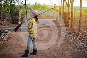 Portrait the farmer asea woman wearing a hat at the shooting range shot from a muzzle-loading vintage gun in the farm, Young girl