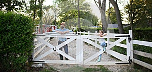 Portrait of farmer family, father and young daughter standin on wooden fence on family farm. Concept of photo