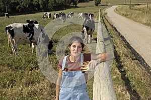 Portrait of a farmer with her cows in the field photo