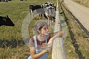 Portrait of a farmer with her cows in the field photo