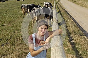 Portrait of a farmer with her cows in the field photo