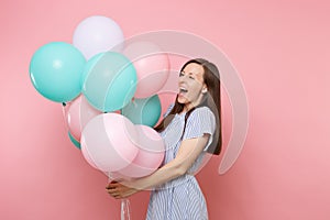 Portrait of fascinating joyful young happy woman wearing blue dress holding colorful air balloons on bright