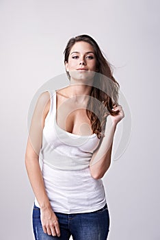 Portrait, fashion and attitude with a young woman in studio on a white background looking confident. Trendy, style and