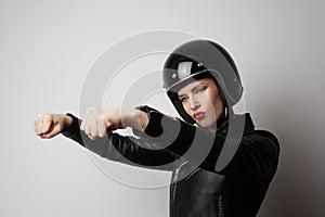 Portrait of fashion beautiful blonde girl in black leather jacket pretending to ride a motorcycle over on white