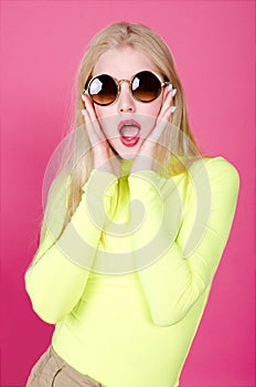 Portrait of fashion blonde model girl young woman wearing stylish with sunglasse  on a pink