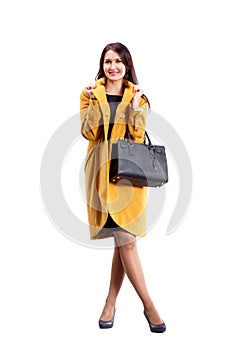 Portrait of fashion girl in yellow coat posing on light backgro