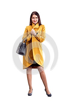 Portrait of fashion girl in yellow coat posing on light backgro