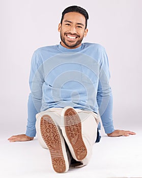 Portrait, fashion and man smile on the floor in studio isolated on a white background. Style, happy and Asian person