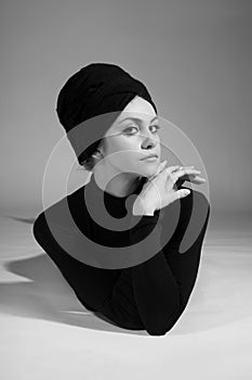 Portrait of fashion model in retro style. Black and white photo in studio