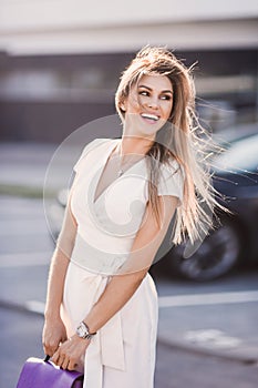 Portrait of Fashion stylish of young hipster blonde woman, elegant lady, bright colors dress, cool girl. City view urban l