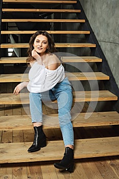 Portrait fashion woman sit on the stairs inside stylish designe interior room