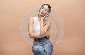 Portrait of fashionable beautiful young sexy Asian woman with natural make-up sitting on a chair and closed eyes.  Lady slim wears