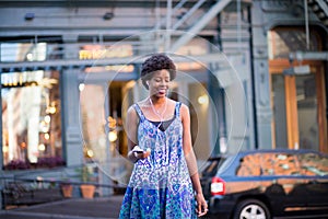 Portrait of fashionable black woman walking on city street while