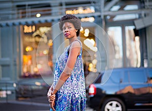 Portrait of fashionable black woman walking on city street