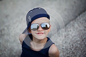 Portrait of Fashionable little boy in sunglasses and cap. Childhood