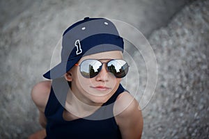 Portrait of Fashionable little boy in sunglasses and cap. Childhood