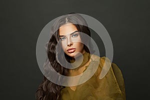 Portrait of fashionable woman with makeup and long curly hair on black background portrait