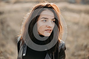 Portrait of a fashionable young Caucasian brunette girl in a leather jacket