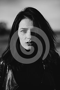 portrait of a fashionable young Caucasian brunette girl in a leather jacket