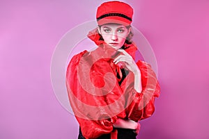 Portrait of fashionable young girl in red hat . pink background