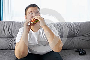 Portrait of fat boy eating sandwich photo