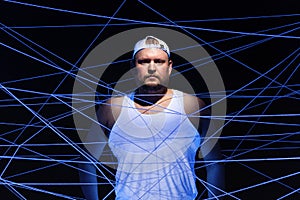 Portrait of fat man tangled in threads in neon light