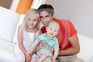 Portrait, father and children with generations at family house by embrace, bonding and love in living room on couch. Dad