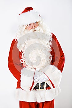 Portrait of father Christmas in studio with white background in a red costume for Christian winter holiday celebration
