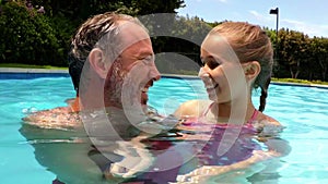 Portrait of father and daughter in swimming pool