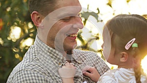 Portrait of father holding child girl in his hands and hugging each other outdoors. Dad cudding and kissing with his