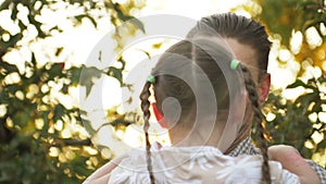 Portrait of father holding child girl in his hands and hugging each other outdoors. Dad cudding and kissing with his