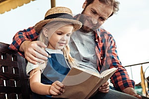 portrait of father hugging daughter while she