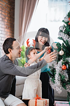 Portrait of Father, Mother, and his daughter install Christmas t