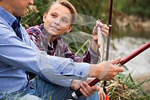 Portrait of father with son having fish