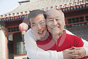 Portrait of father and son outside traditional Chinese building